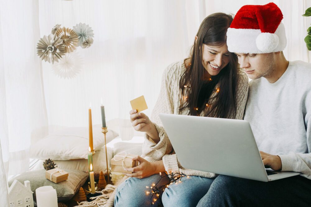 happy couple buying gifts online using laptop and 8CABCEZ