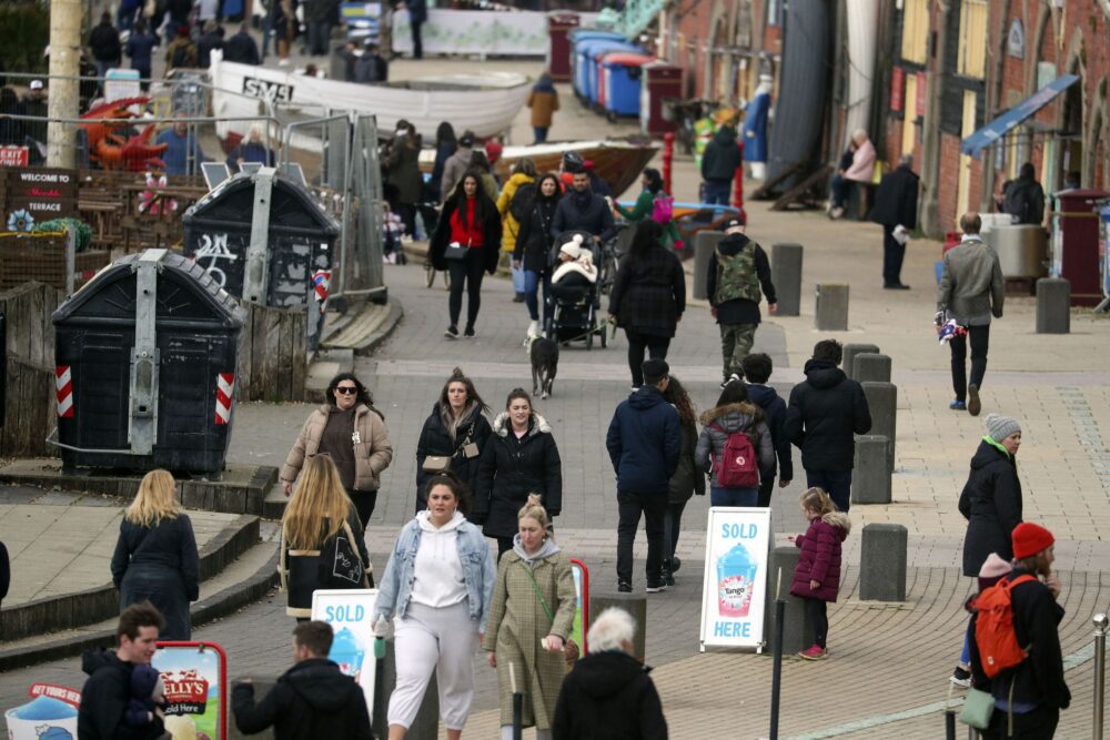 Spring People walk along the seafront in Brighton, East SussexApr 2nd 2021