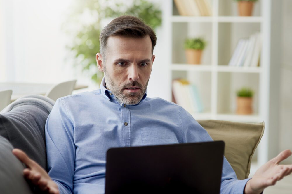 angry man working home on a computer EKMM5N5 1