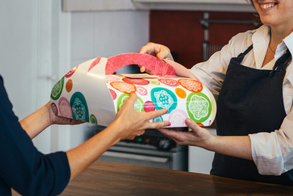 happy baker gives cake to customer PKB3CTK